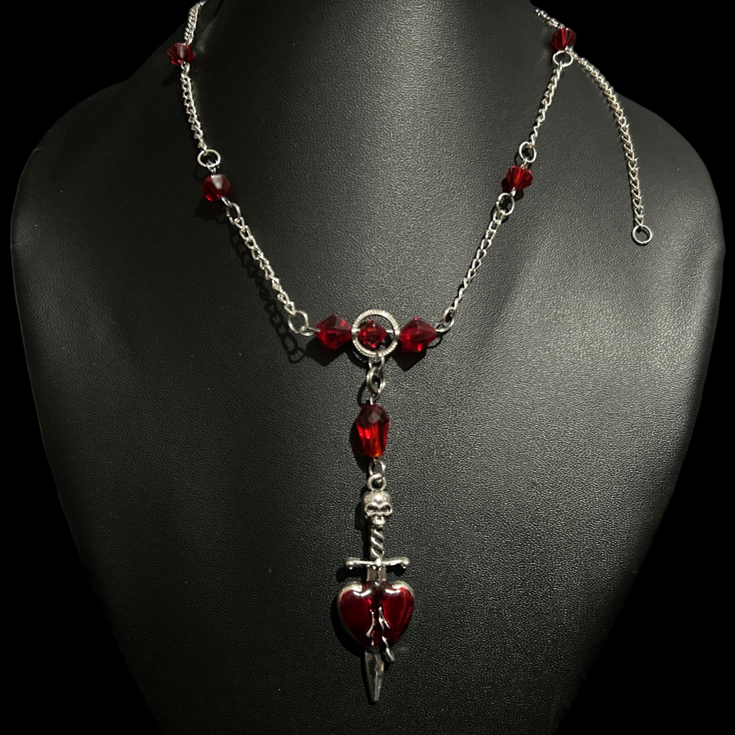 Full view of Phantom Cat India's Crimson Heart Gothic Necklace on mannequin bust with red stones and skeletal dagger pendant. Fantasy and whimsical accessories and jewelry.