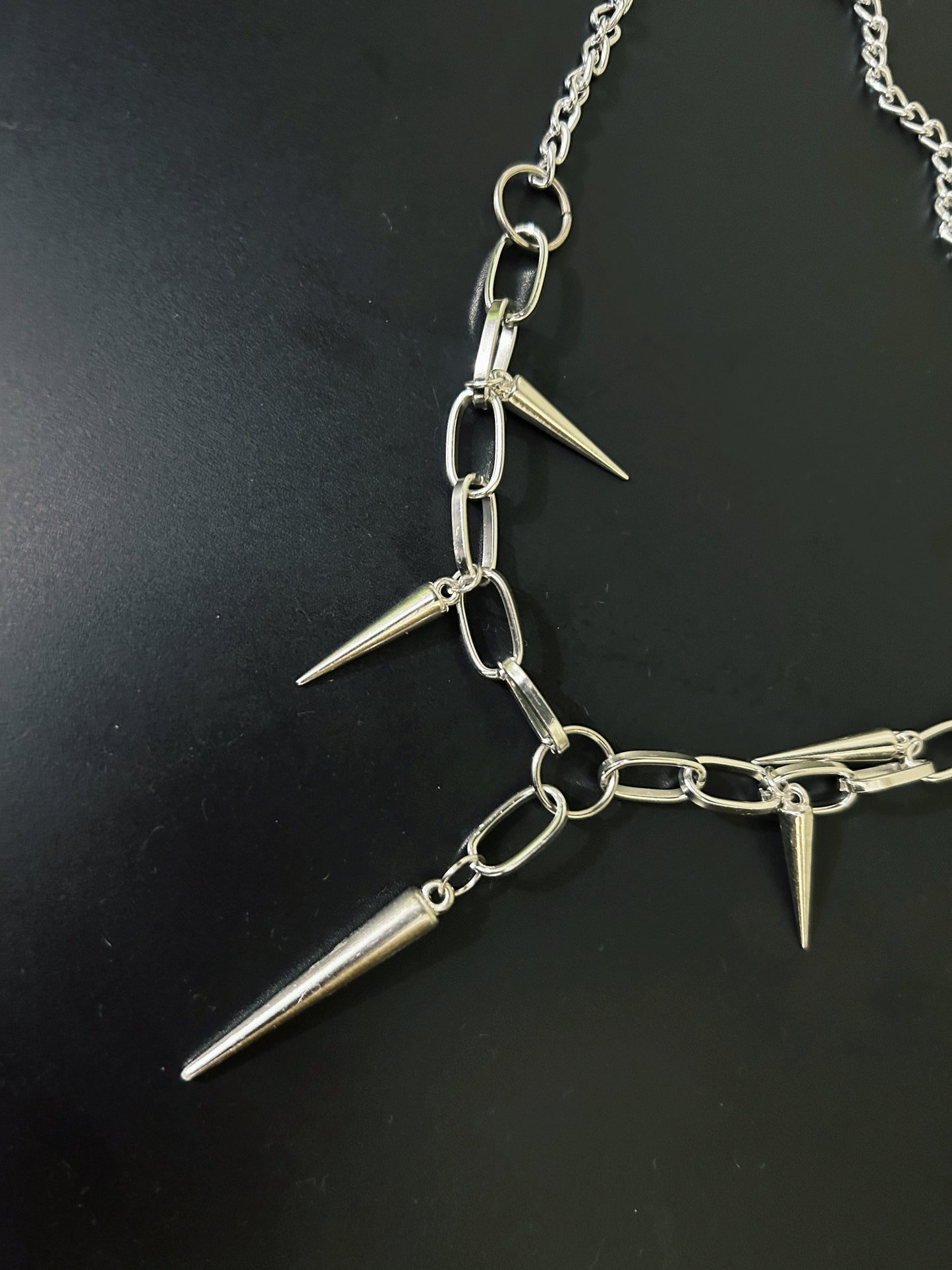 Close-up of gothic spikes necklace with thick, chunky chain. Shop bold grunge fashion accessories for alt and rock-inspired outfits in India.