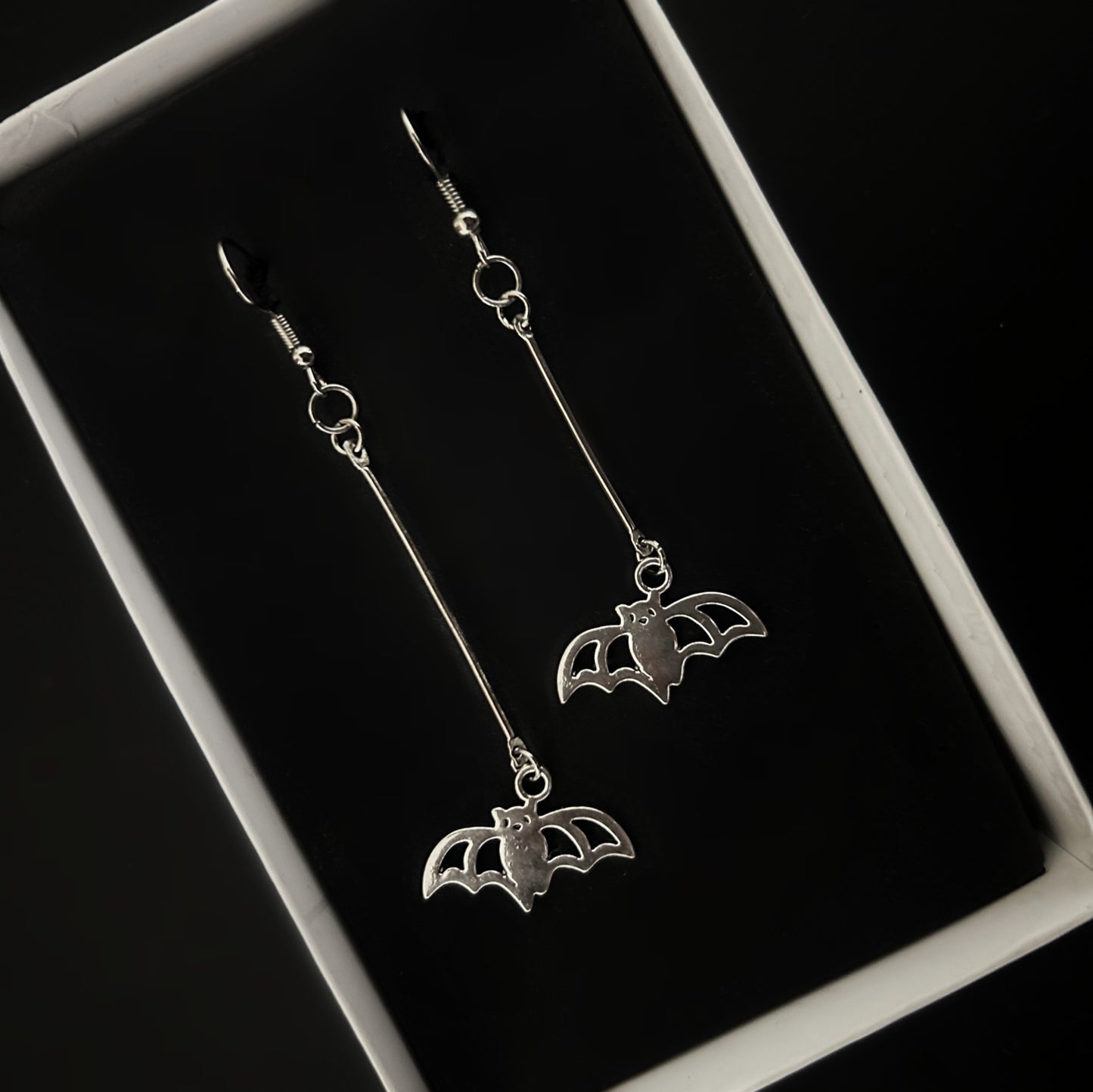 Top view of lightweight batman silver earrings β gothic and concert fashion accessories India, Phantom Cat alt jewelry for daily wear.