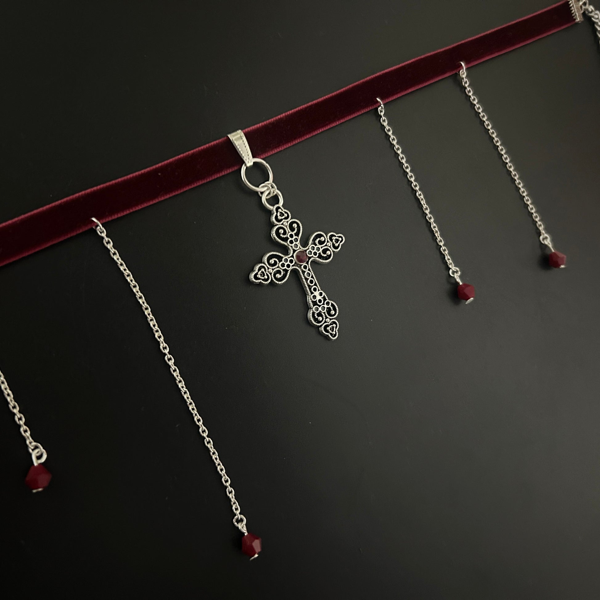 Flatlay of maroon velvet gothic choker with detailed silver cross and hanging chain accents – gothic jewelry, fantasy style, y2k alternative look