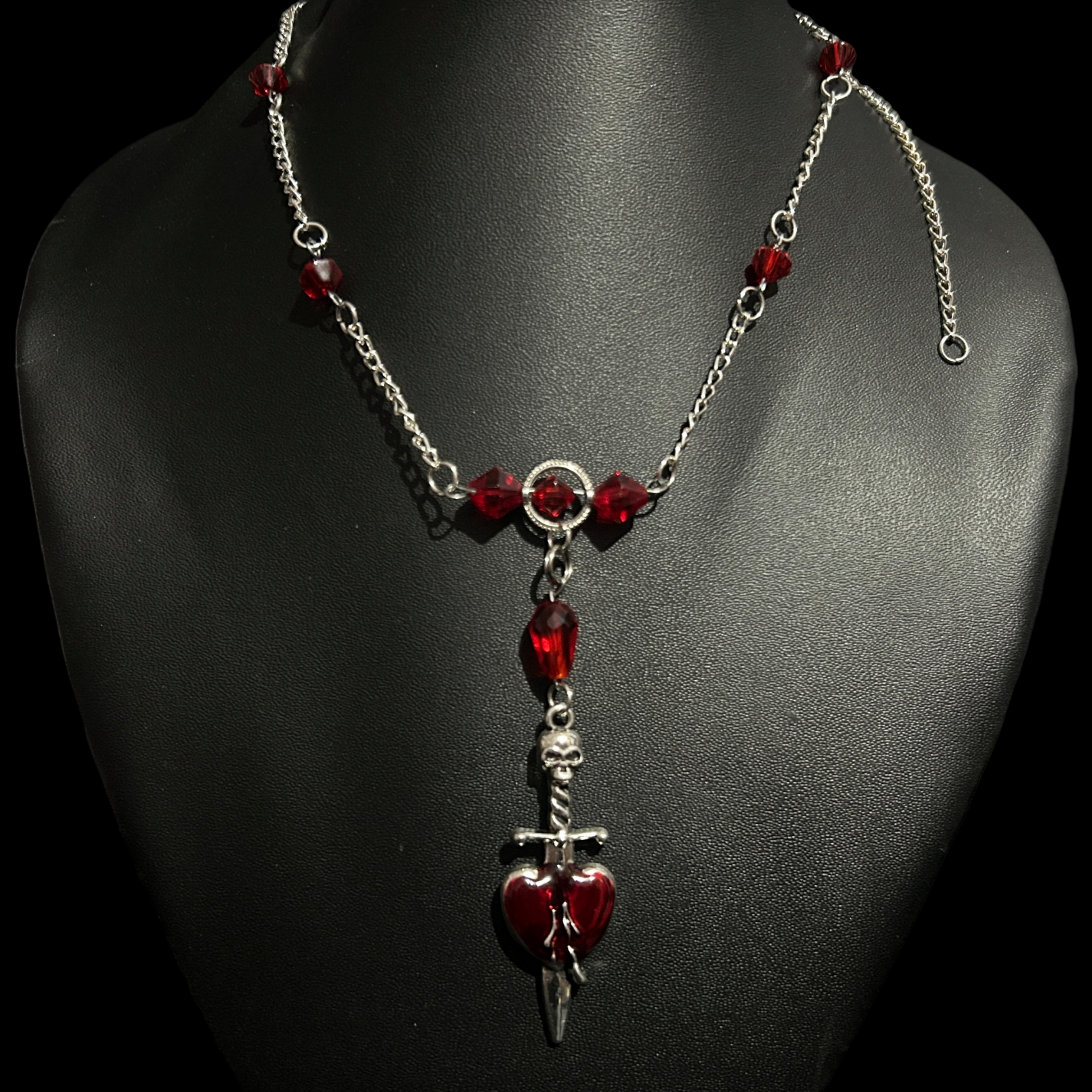 Full view of Phantom Cat India's Crimson Heart Gothic Necklace on mannequin bust with red stones and skeletal dagger pendant. Fantasy and whimsical accessories  and jewelry.