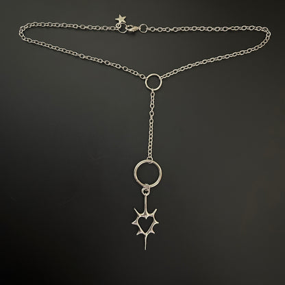 Y-drop silver necklace feat. a gothic spiked heart pendant with oversized rings, laid flat. Tarnish-resistant alt jewelry ideal for gothic fashion, anime cosplay, and grunge-inspired K-pop styling.