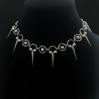 Close-up of gothic chainmail choker necklace with chainmaille rings, polished silver beads and cone spikes. Shop grunge and alt jewelry with an industrial edge in India