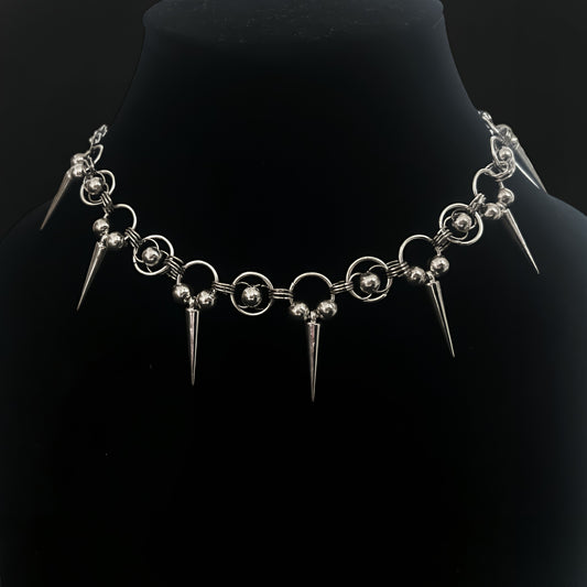 Close-up of gothic chainmail choker necklace with chainmaille rings, polished silver beads and cone spikes. Shop grunge and alt jewelry with an industrial edge in India