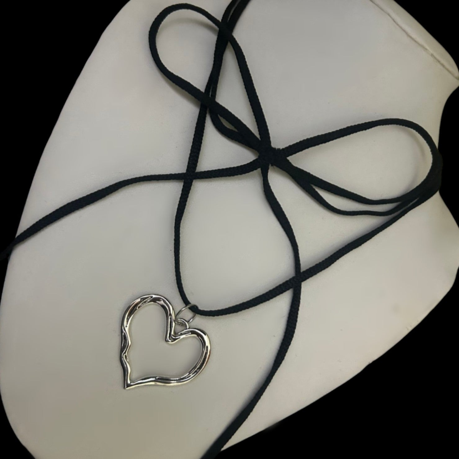 Close-up of layered velvet wrap choker with hollow silver heart charm on bust. Alt fashion jewelry India. Soft, adjustable collar for gothic looks.