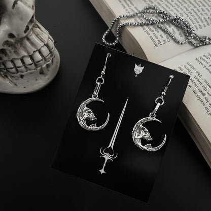 Fantasy skull earrings by Phantom Cat featuring occult-inspired crescent moon shapes. Gothic alt accessories for lovers of y2k and anime cosplay fashion. Made in India.