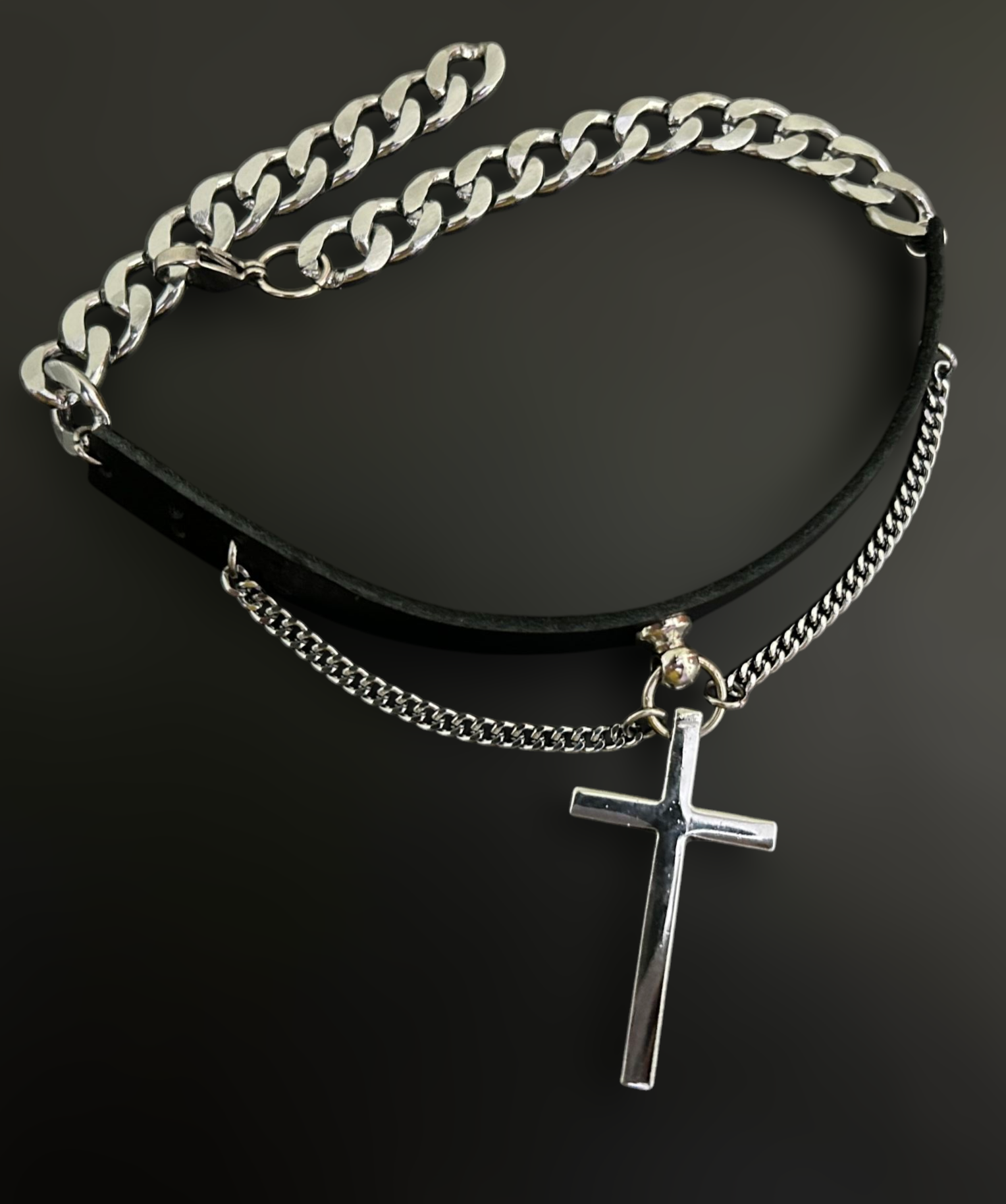 Flat lay of gothic leather collar choker with cross pendant. Unisex stainless steel jewelry and alt fashion accessories by Phantom Cat. Inspired by gothic themes in the Netflix Miniseries 'Midnight Mass.' 