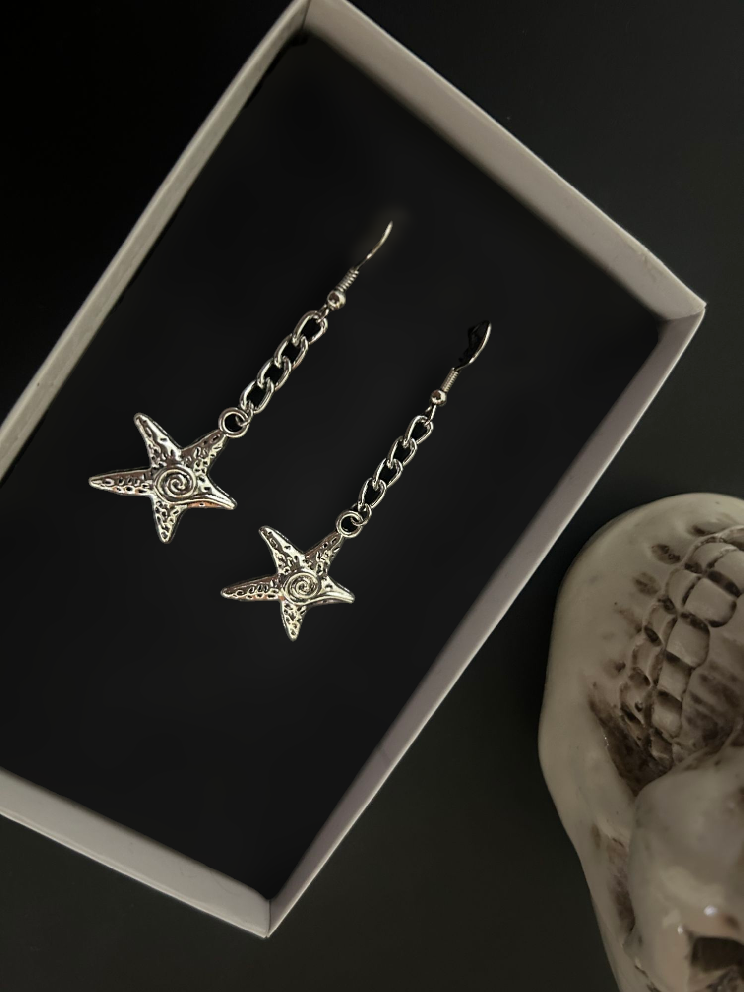 Top view of star dangle earrings on curb chain —  Alt and gothic jewelry online Shop in India, celestial gothic earrings for y2k, kpop, cosplay and fantasy styling.
