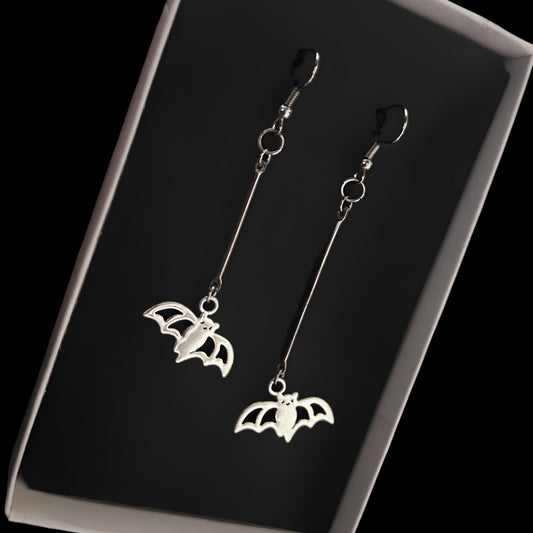Boxed close-up of gothic silver bat dangle earrings by Phantom Cat India. Shop alt and grunge jewelry and accessories online for vampirecore and kpop styling.
