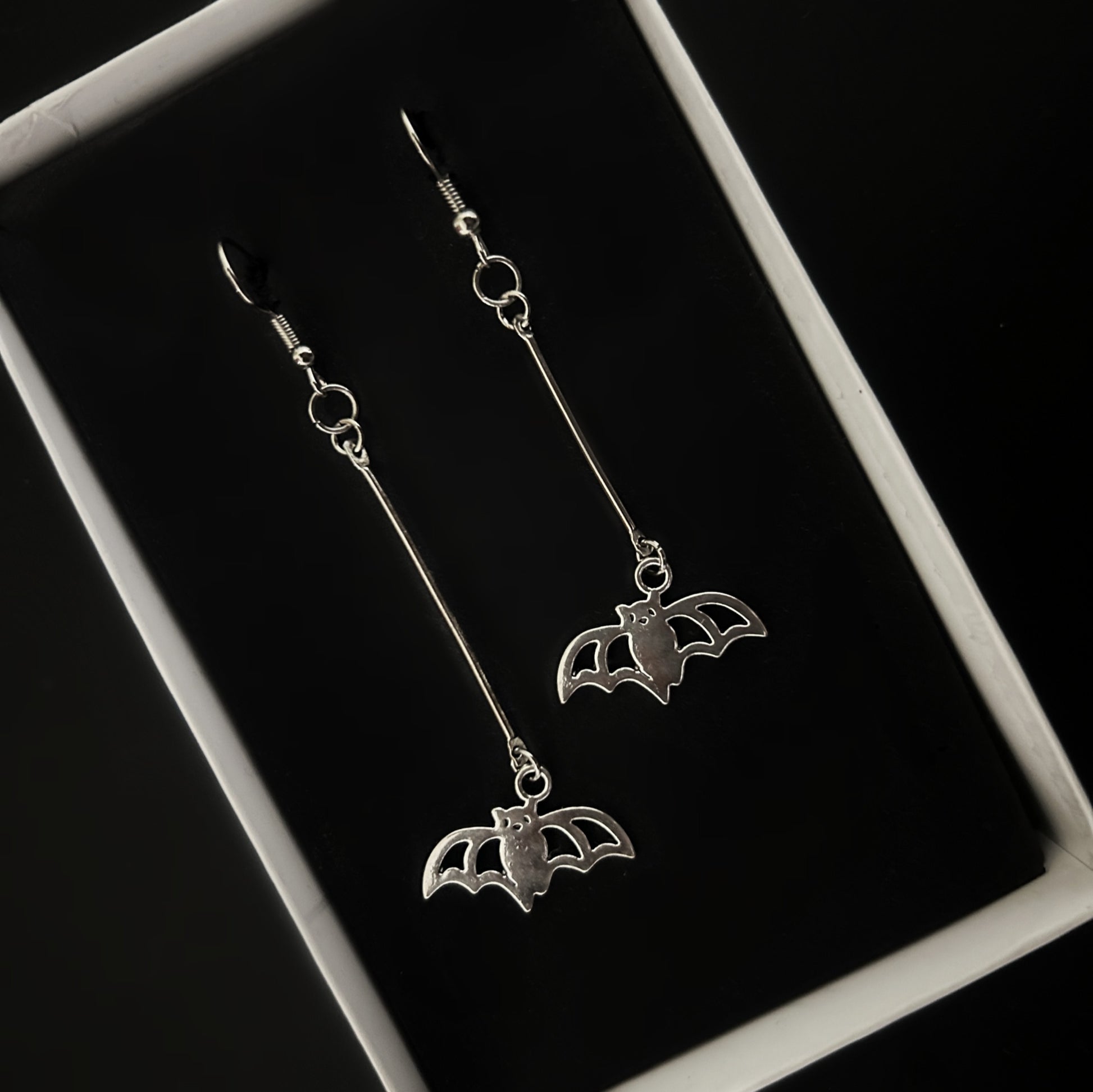 Top view of lightweight batman silver earrings — gothic and concert fashion accessories India, Phantom Cat alt jewelry for daily wear.